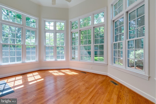 unfurnished sunroom with a wealth of natural light and ceiling fan