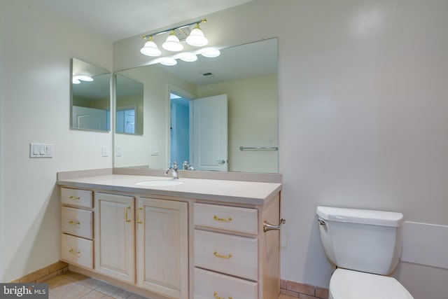 bathroom featuring vanity, toilet, and tile floors