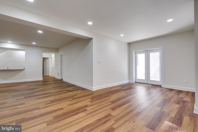 unfurnished living room with hardwood / wood-style flooring and french doors