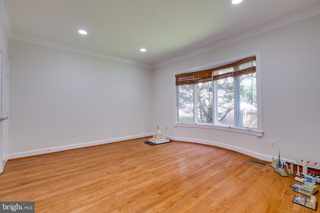 empty room featuring ornamental molding and light hardwood / wood-style floors