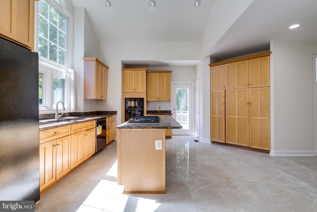 kitchen featuring dark stone countertops, a kitchen island, light tile floors, black appliances, and light brown cabinetry