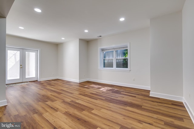 unfurnished room featuring plenty of natural light, french doors, and hardwood / wood-style flooring