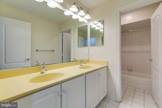 bathroom featuring dual sinks, tiled shower / bath combo, tile floors, and large vanity