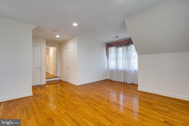 additional living space featuring light hardwood / wood-style floors and lofted ceiling