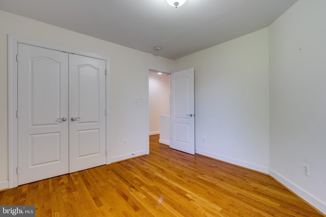 unfurnished bedroom with a closet and light wood-type flooring