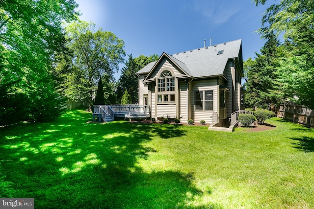 rear view of house featuring a deck and a yard