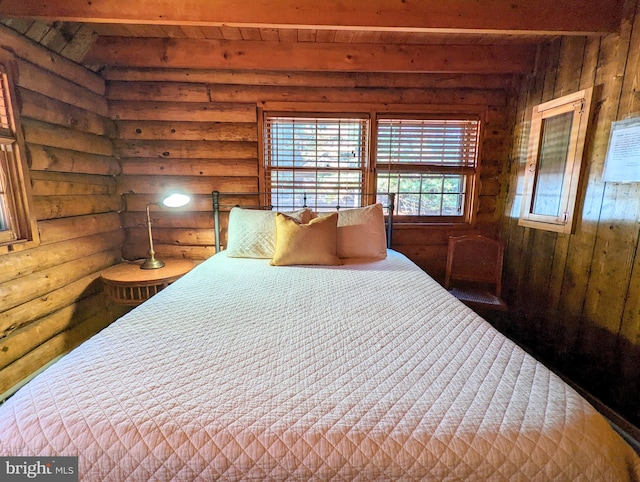 bedroom with log walls and beam ceiling