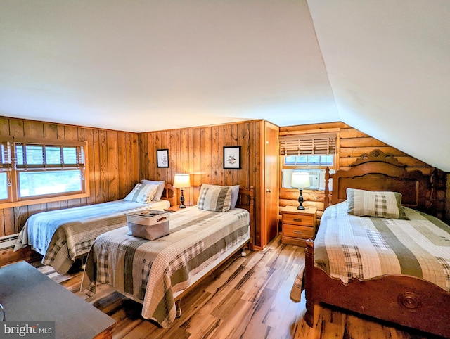 bedroom with lofted ceiling, hardwood / wood-style flooring, and wooden walls