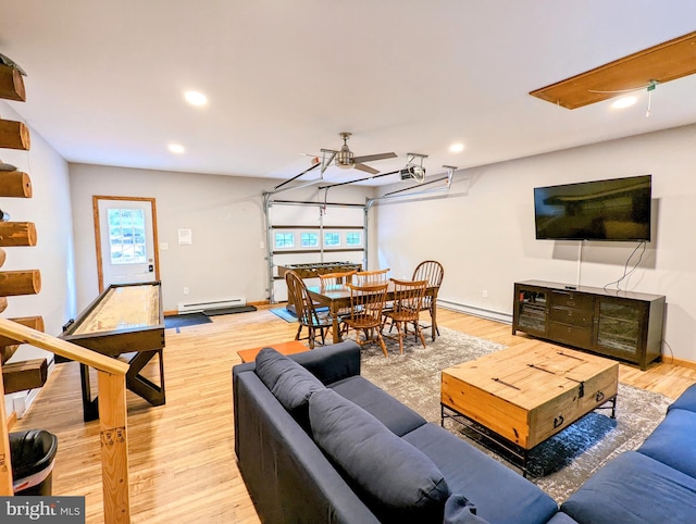 living room featuring ceiling fan, a healthy amount of sunlight, hardwood / wood-style flooring, and a baseboard heating unit