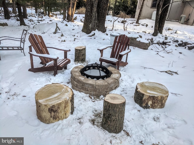 snow covered patio featuring an outdoor fire pit