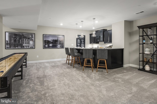 kitchen featuring carpet, kitchen peninsula, and a breakfast bar