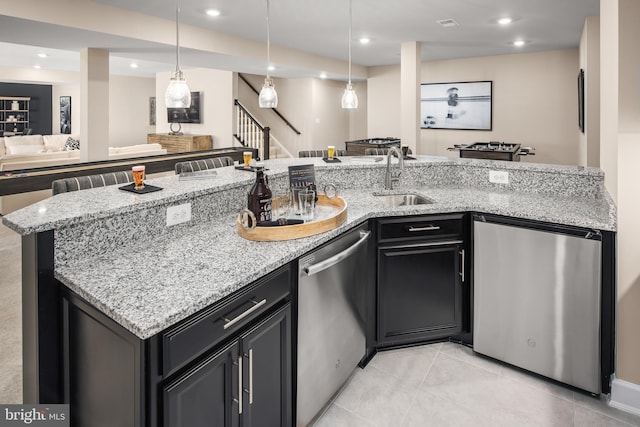 kitchen featuring light tile floors, stainless steel dishwasher, and light stone countertops