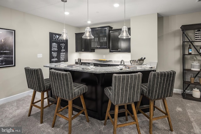 kitchen featuring dark colored carpet and a breakfast bar area