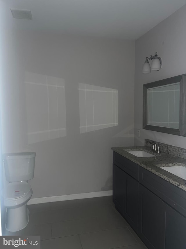 bathroom featuring double sink vanity, toilet, and tile floors