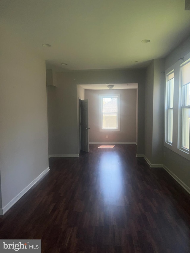 unfurnished room with dark hardwood / wood-style flooring