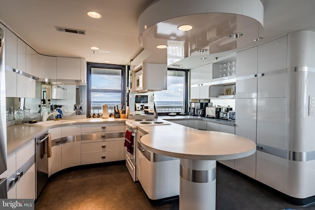 kitchen with sink, stainless steel appliances, kitchen peninsula, and white cabinetry