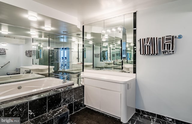 bathroom with vanity, tile floors, and tiled bath