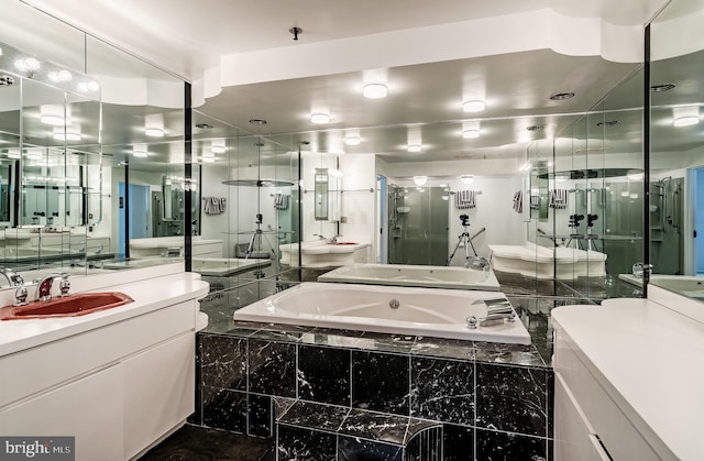 bathroom with vanity with extensive cabinet space and separate shower and tub