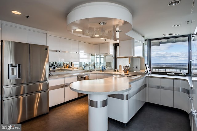 kitchen featuring kitchen peninsula, appliances with stainless steel finishes, and white cabinets