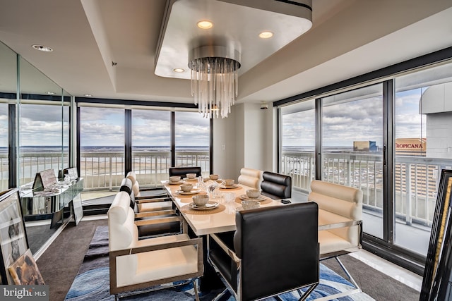 carpeted dining area with a wall of windows and a chandelier