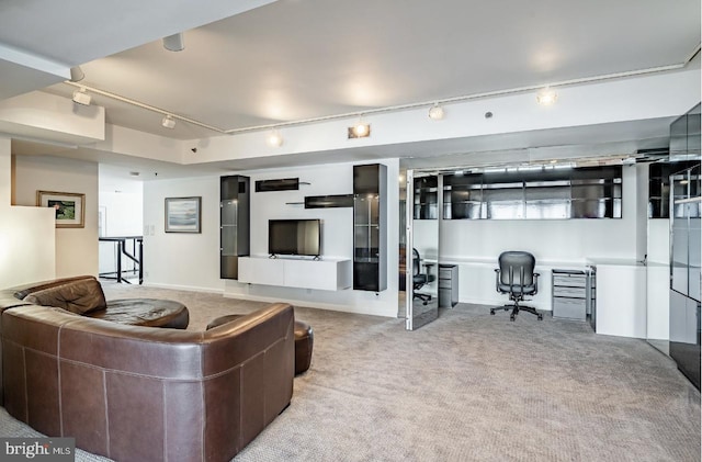 living room with rail lighting, light colored carpet, and built in desk