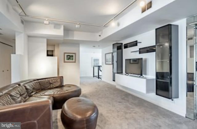 carpeted living room featuring track lighting