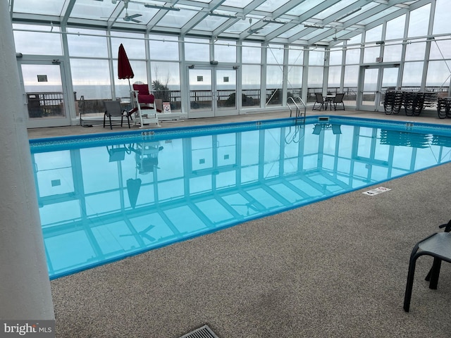 view of pool with glass enclosure