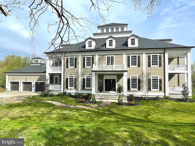 view of front of property featuring a balcony, a garage, and a front lawn