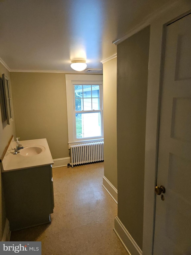 bathroom with ornamental molding, vanity, and radiator heating unit