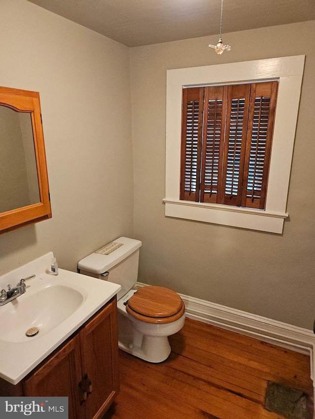 bathroom with hardwood / wood-style floors, vanity, and toilet