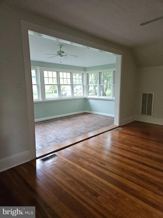 spare room with ceiling fan and dark wood-type flooring