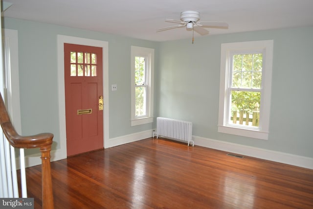 foyer entrance featuring hardwood / wood-style flooring, plenty of natural light, radiator, and ceiling fan