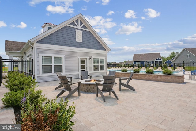 view of terrace with a fire pit and a fenced in pool