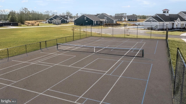 view of tennis court featuring a yard