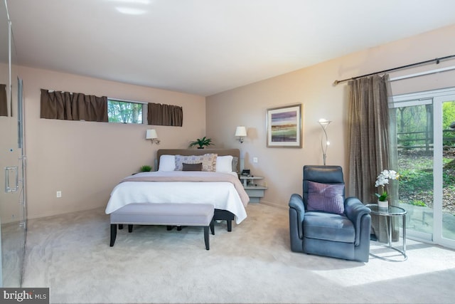 bedroom with access to outside and light colored carpet