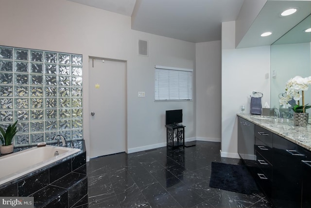 bathroom featuring vanity and tiled bath