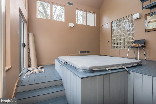 deck featuring a wall unit AC and a covered hot tub