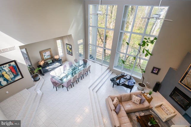 tiled living room with a high ceiling and ceiling fan