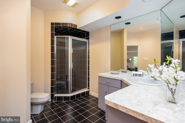 bathroom featuring vanity, tile patterned flooring, toilet, and an enclosed shower