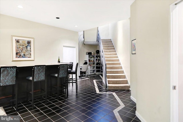 interior space with tile patterned floors and indoor bar