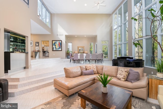 living room featuring a high ceiling, light tile patterned flooring, and plenty of natural light