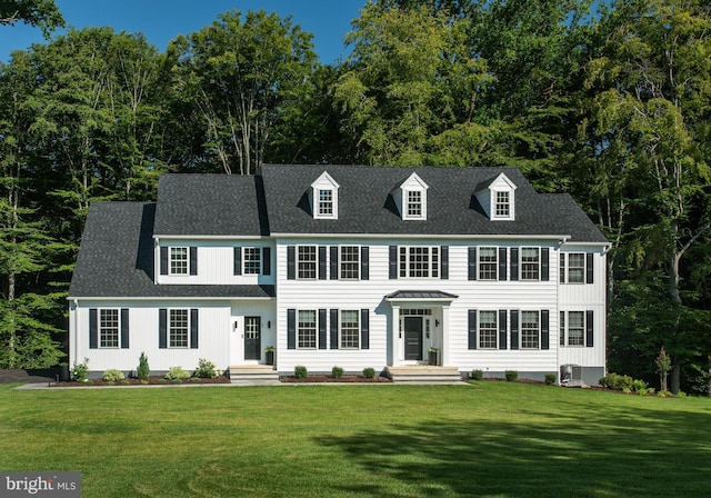 view of front of house with a front lawn and central air condition unit