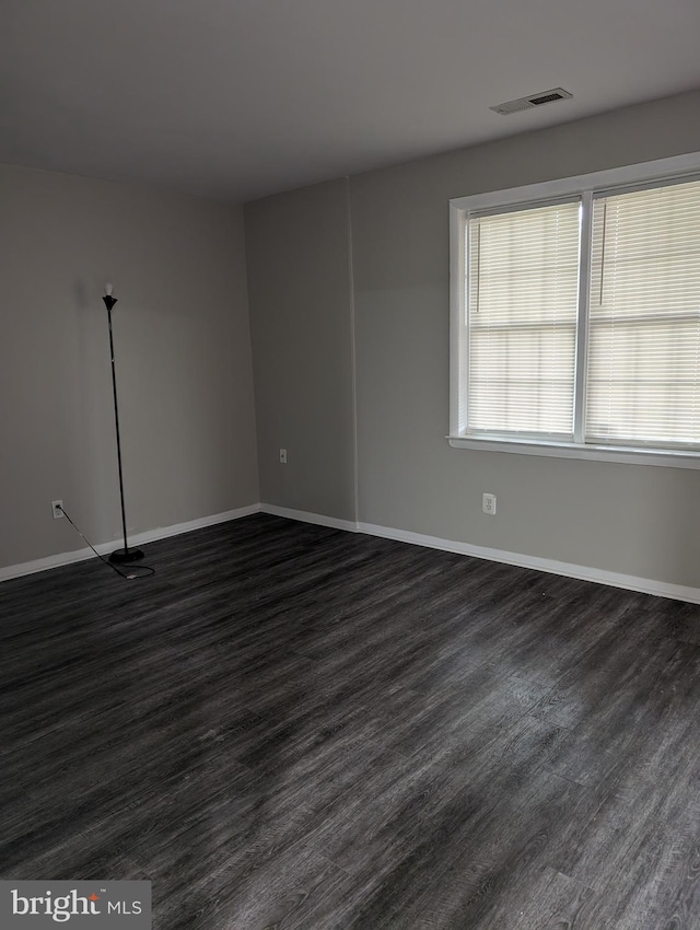 spare room featuring dark wood-type flooring