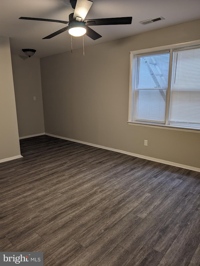 unfurnished room with dark hardwood / wood-style flooring and ceiling fan