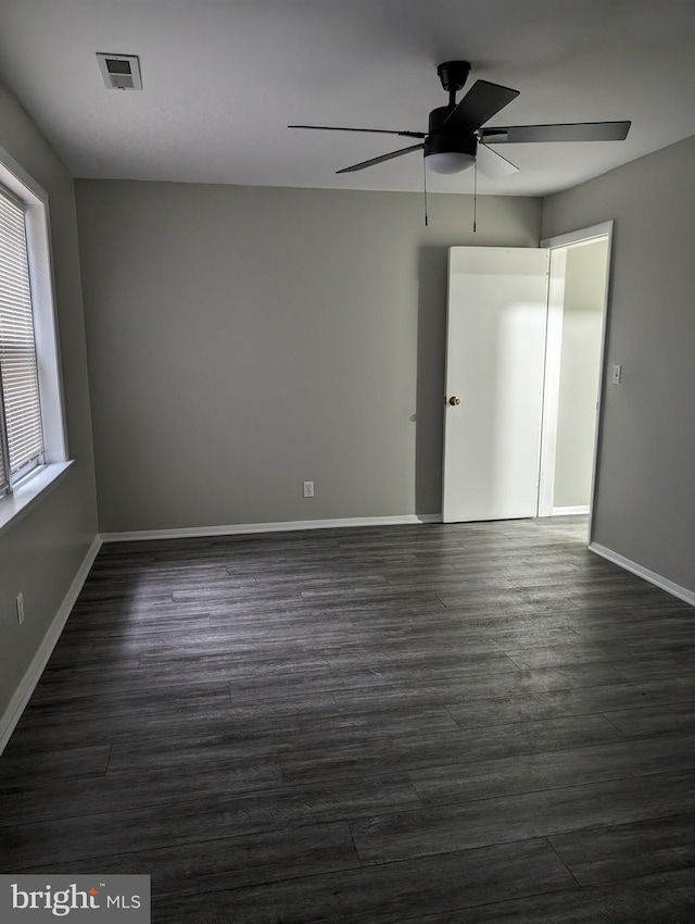 empty room with dark hardwood / wood-style floors and ceiling fan