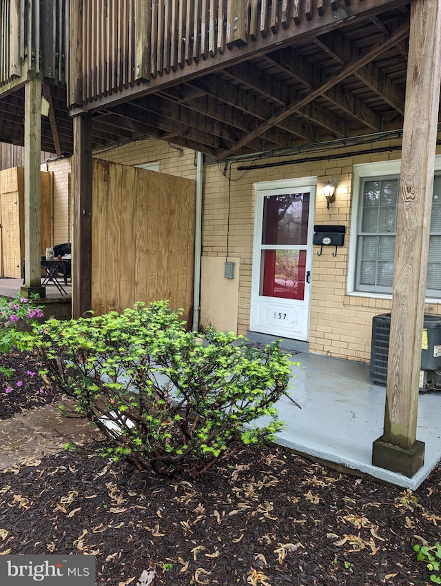 doorway to property with a wooden deck and central AC