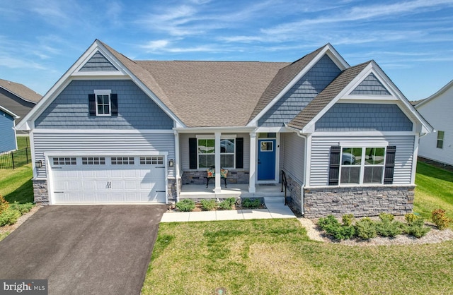 craftsman-style house featuring a porch, a garage, and a front lawn