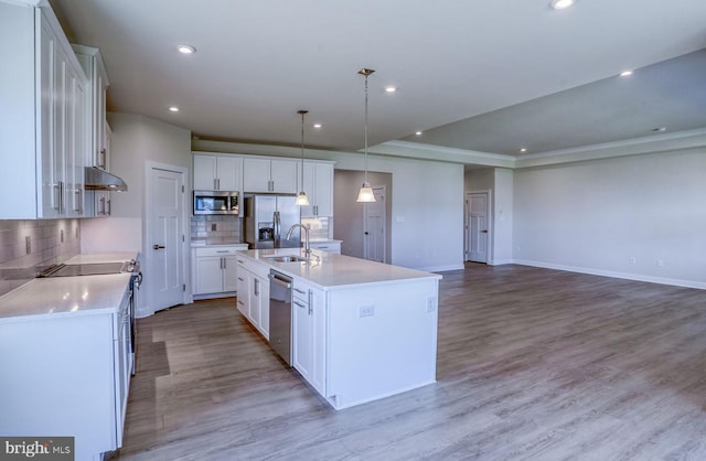 kitchen with white cabinetry, hanging light fixtures, stainless steel appliances, an island with sink, and light wood-type flooring