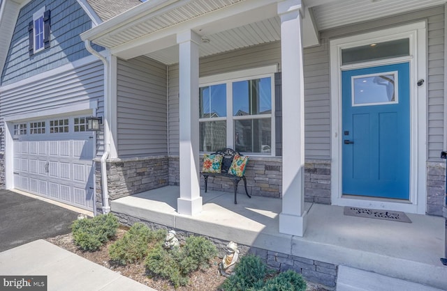 doorway to property with a garage and covered porch