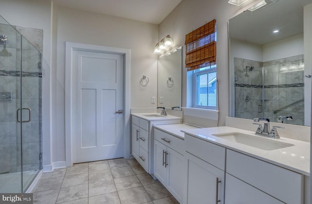 bathroom with tile patterned flooring, vanity, and a shower with door